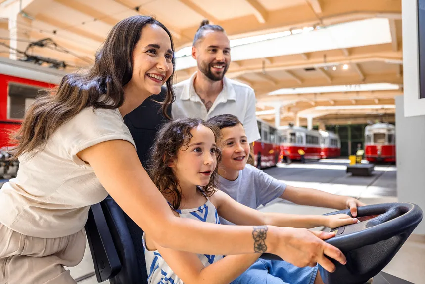 Eine Frau, ein Mann und zwei Kinder am Bussimulator in der Remise