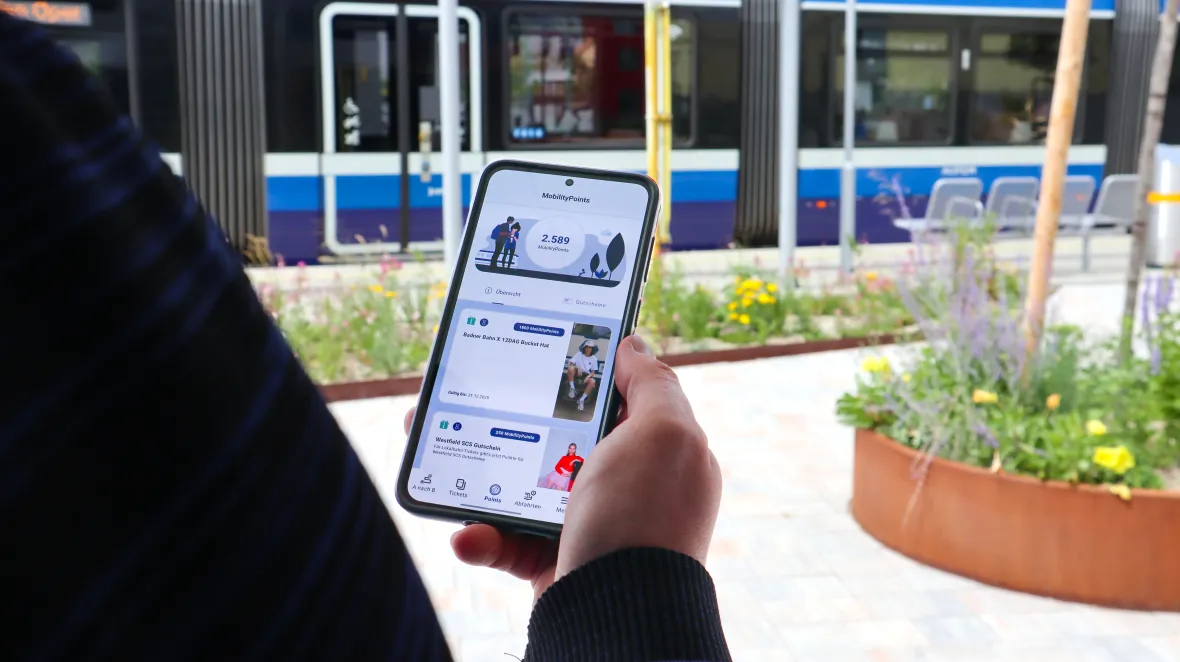 Person hat ein Smartphone in der Hand, auf dem Display sieht man die easymobil-App